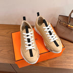 Beige leather sneakers with white laces and black heel-tab accents, chunky tread sole