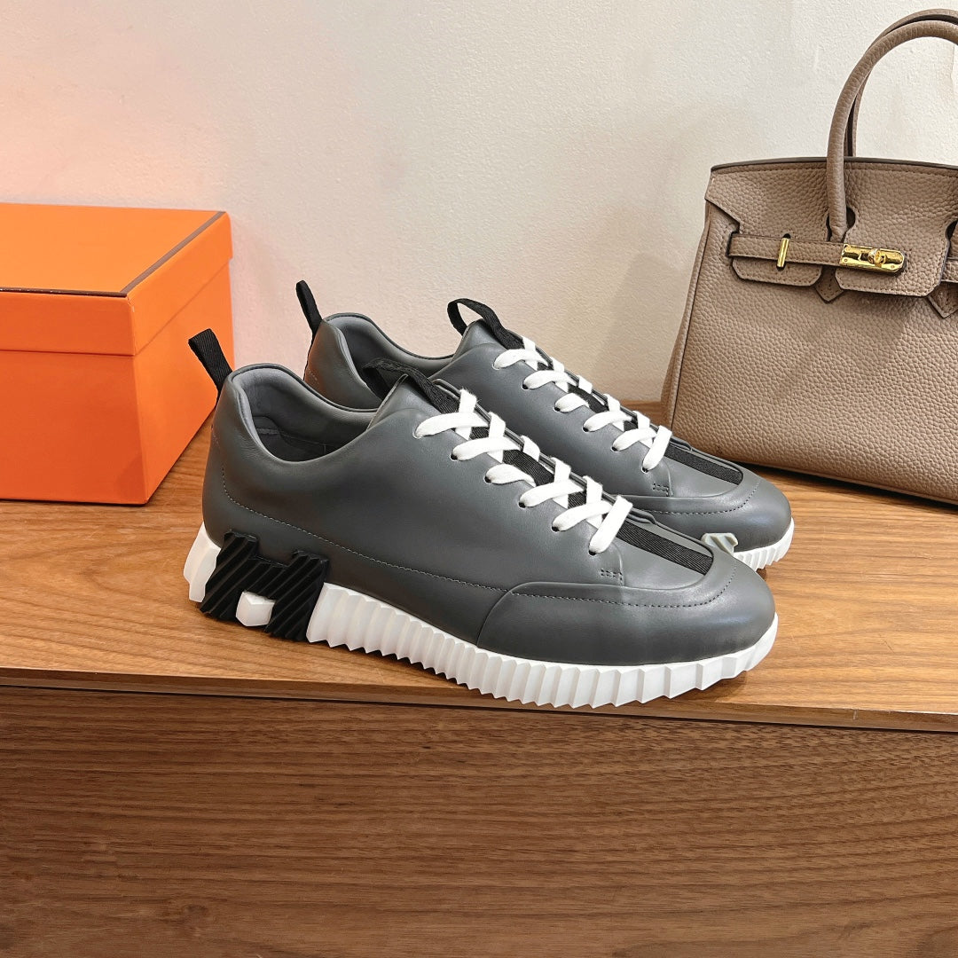 Unisex dark gray sneakers with white laces and contrasting white midsole