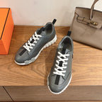 Unisex dark gray sneakers with white laces, side panels, and thick white sole