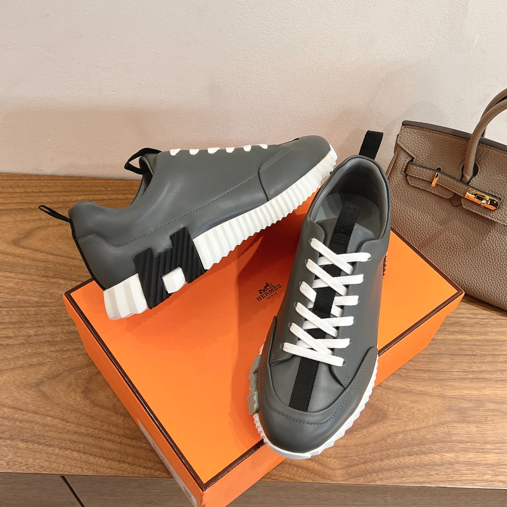 Unisex dark gray sneakers with white laces and white ridged sole detail