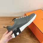 Unisex dark gray sneaker with white laces and white striped sole