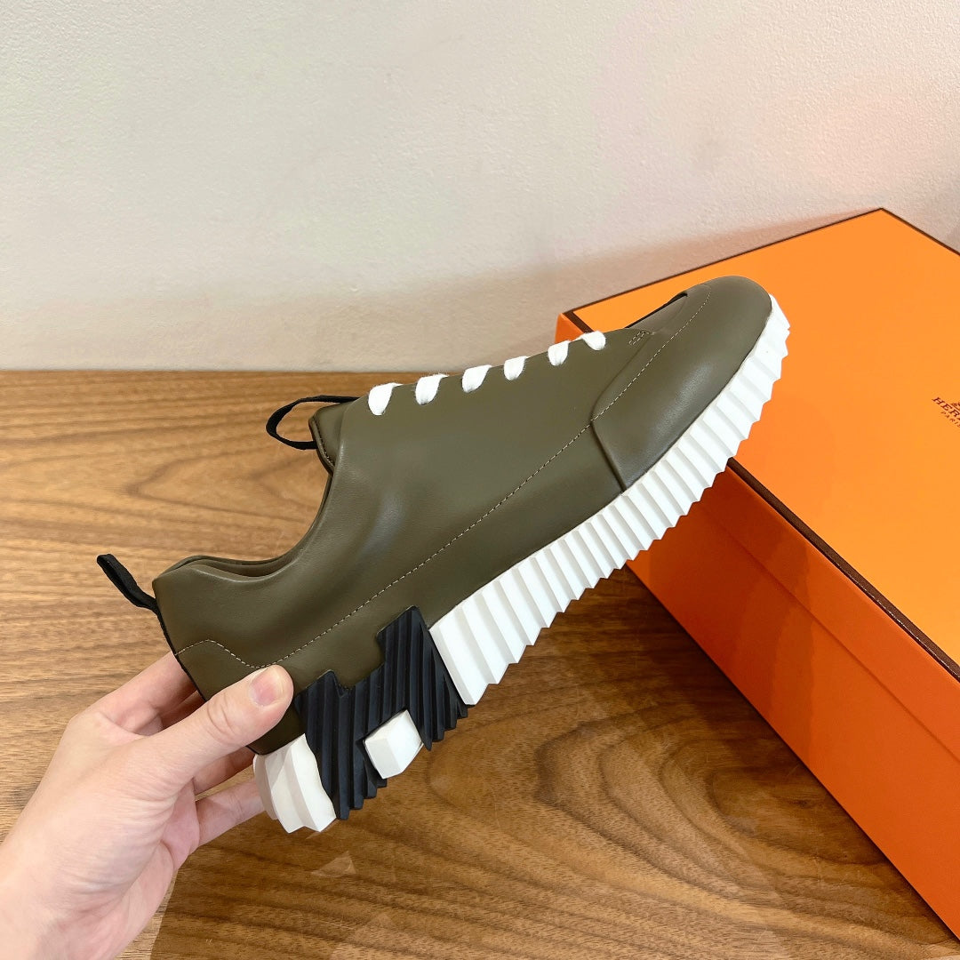 Olive leather sneaker with black lace pull tab and white tread sole