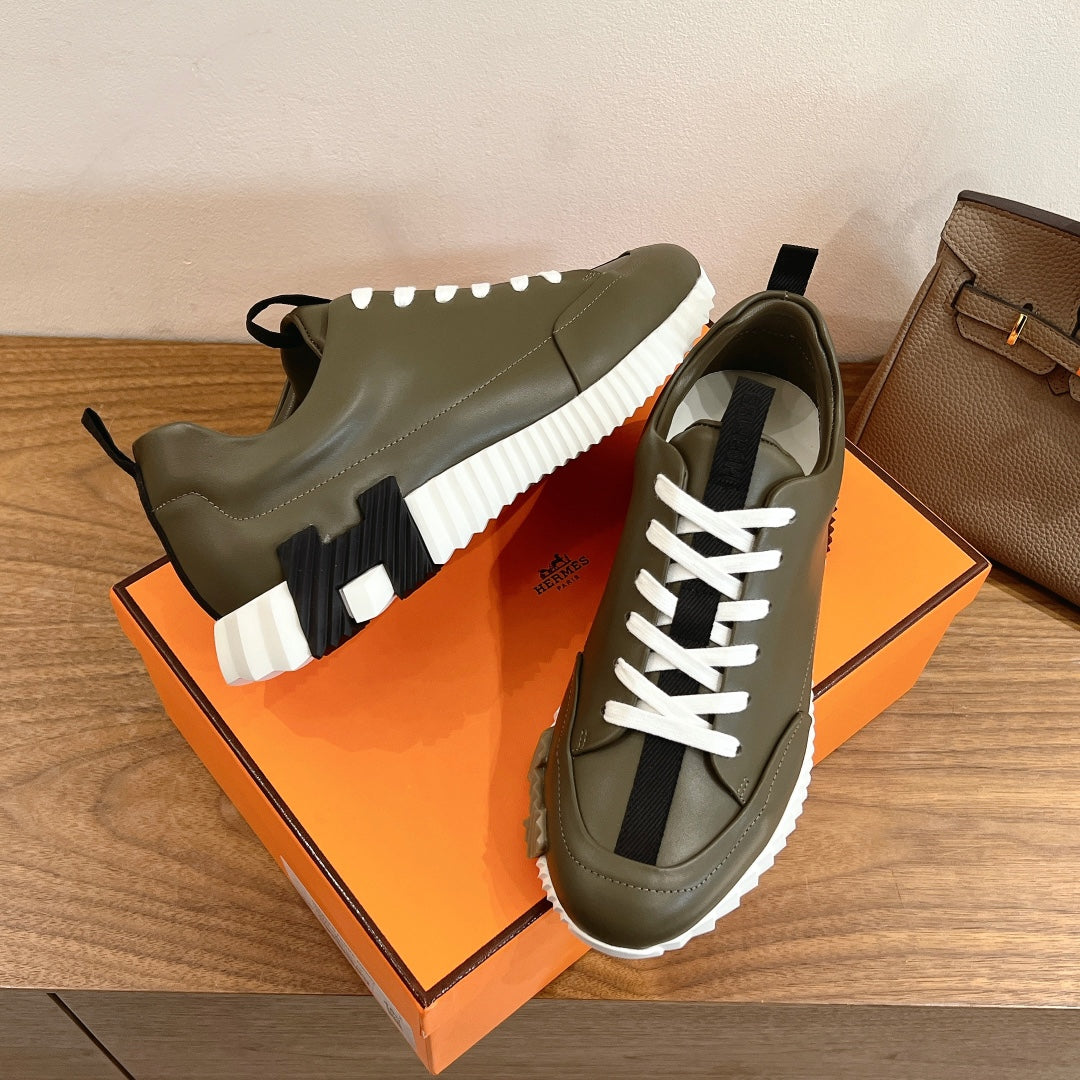 Olive leather sneakers with white laces and black sock-like detail, chunky white sole