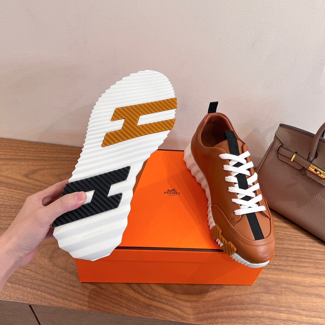 Sneaker outsole view with brown tread detail and white rubber sole on box