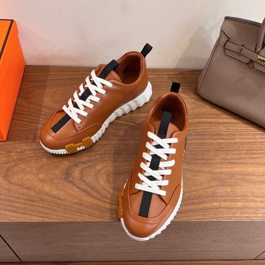 Tan leather sneakers with white lace-up and black side stripe on chunky sole