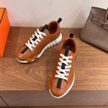 Tan leather sneakers with white lace-up and black side stripe on chunky sole