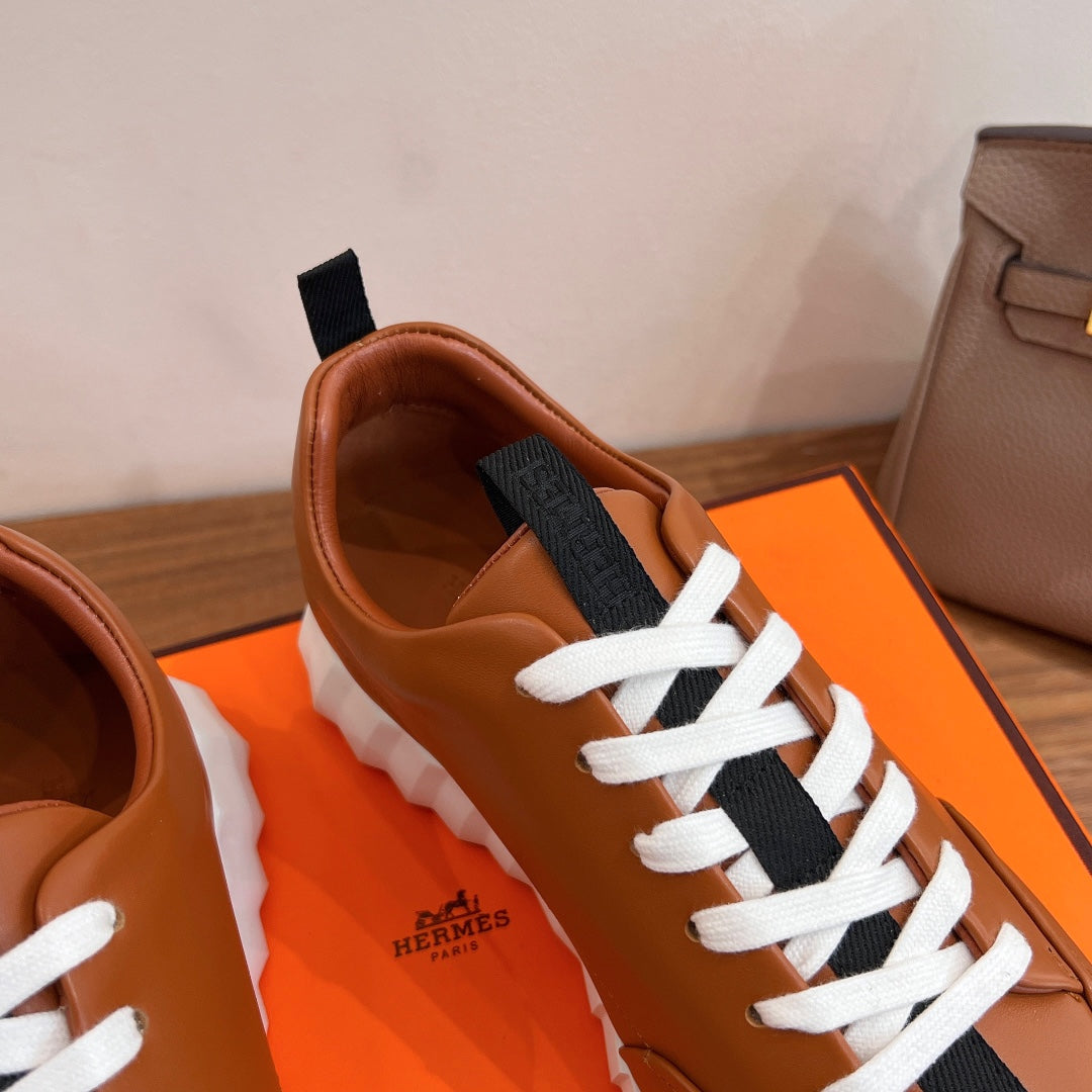 Tan leather sneaker upper close-up with black strap and white lace-up