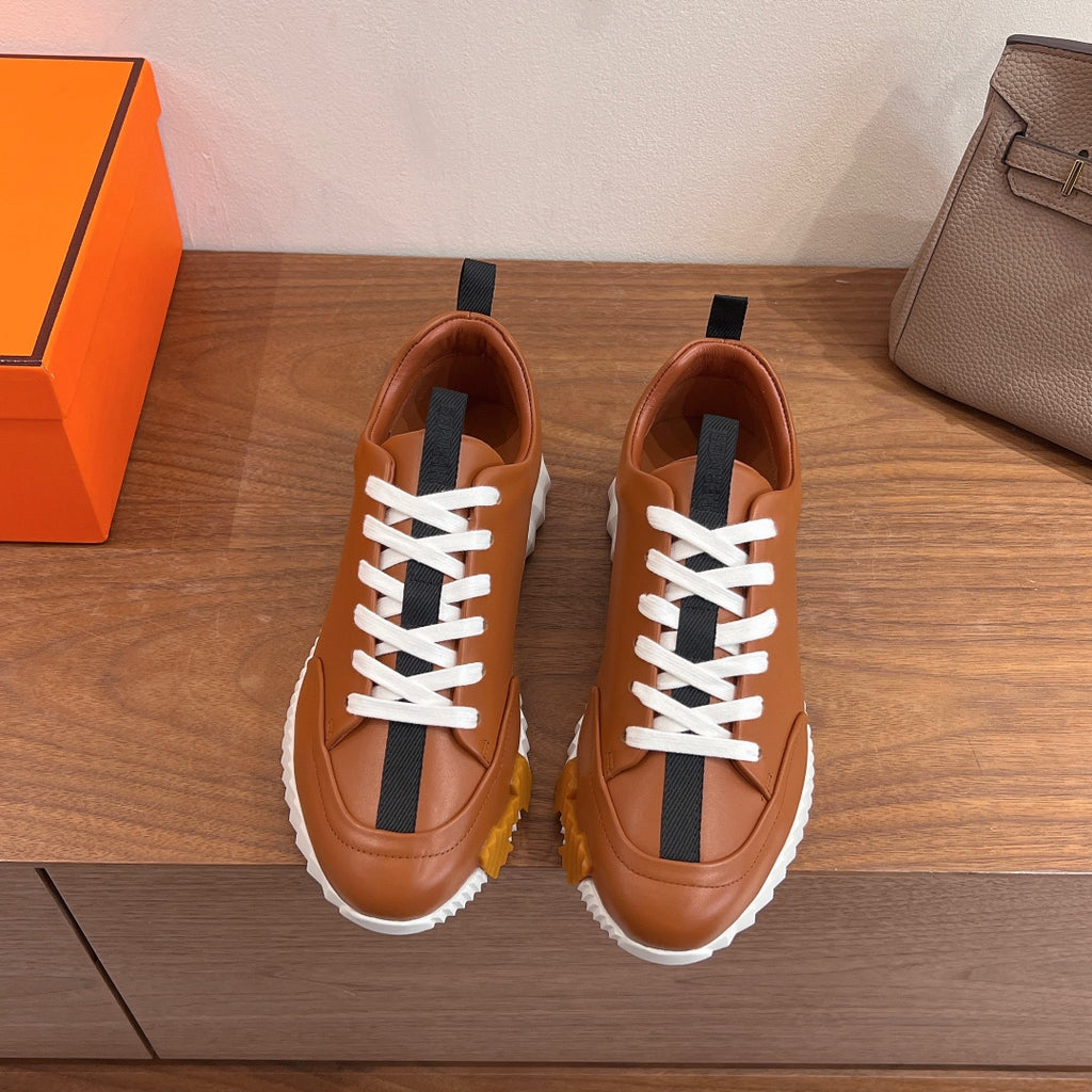 Tan leather sneakers with white laces and black side strap detail