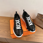 Pair of black leather sneakers with white lace-up ties and thick white sole