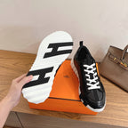 Bottom view of black sneaker outsole with white tread and bold pattern