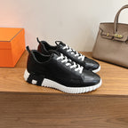 Black leather lace-up sneaker with white laces and white treaded midsole