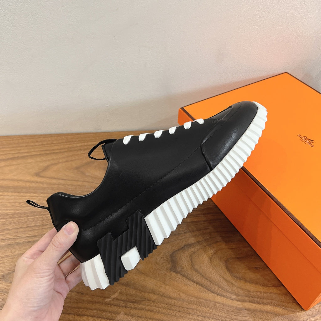 Black Chelsea-style sneakers with ribbed white sole and lace-up front