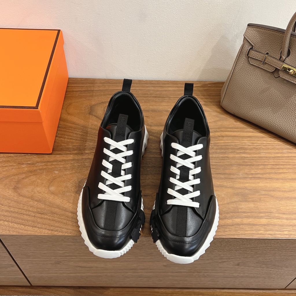 Black leather sneakers with white laces and chunky white rubber sole