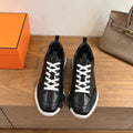 Black leather sneakers with white laces and chunky white rubber sole