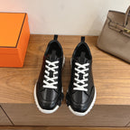 Black leather sneakers with white laces and chunky white rubber sole