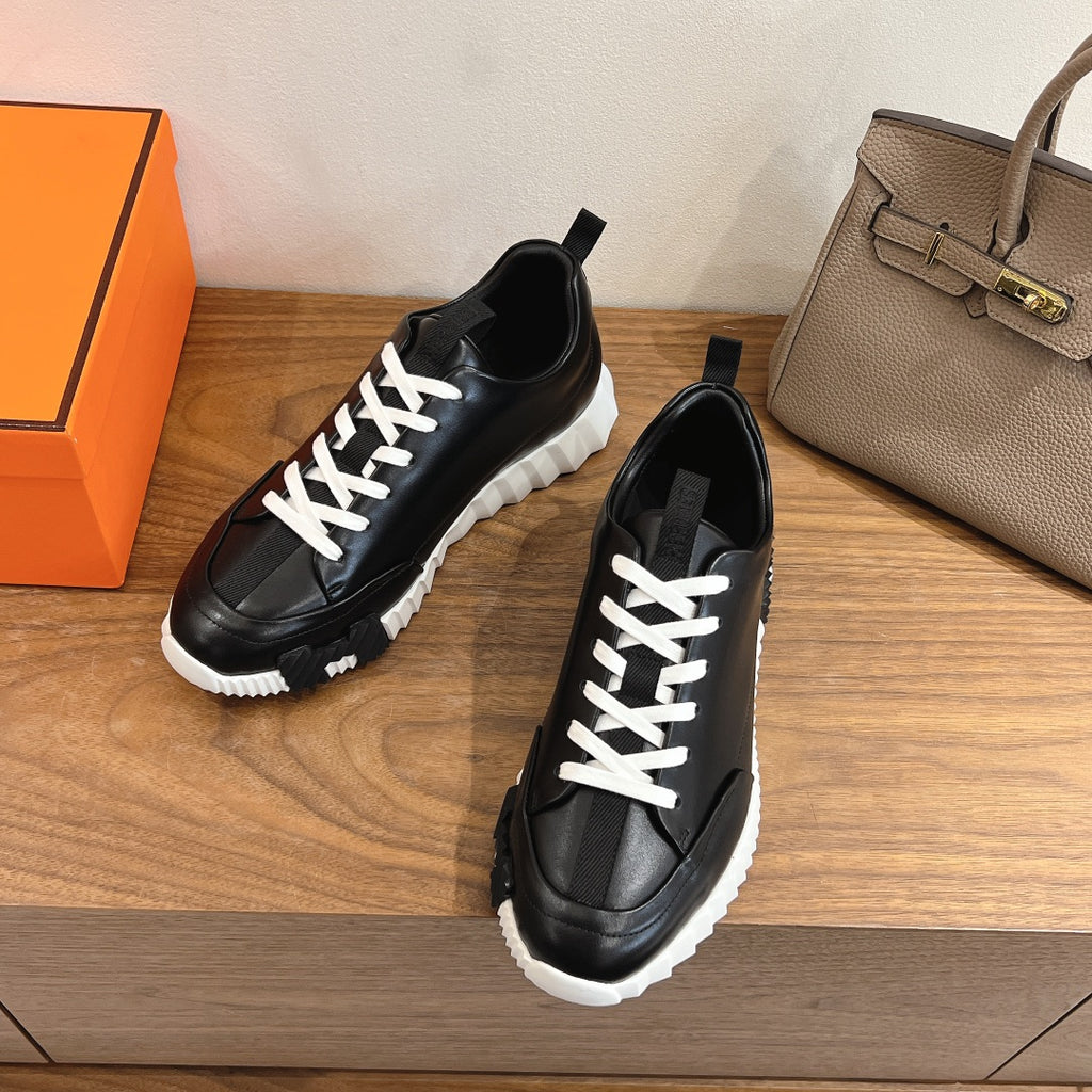 Black lace-up sneakers with white laces and chunky white outsole