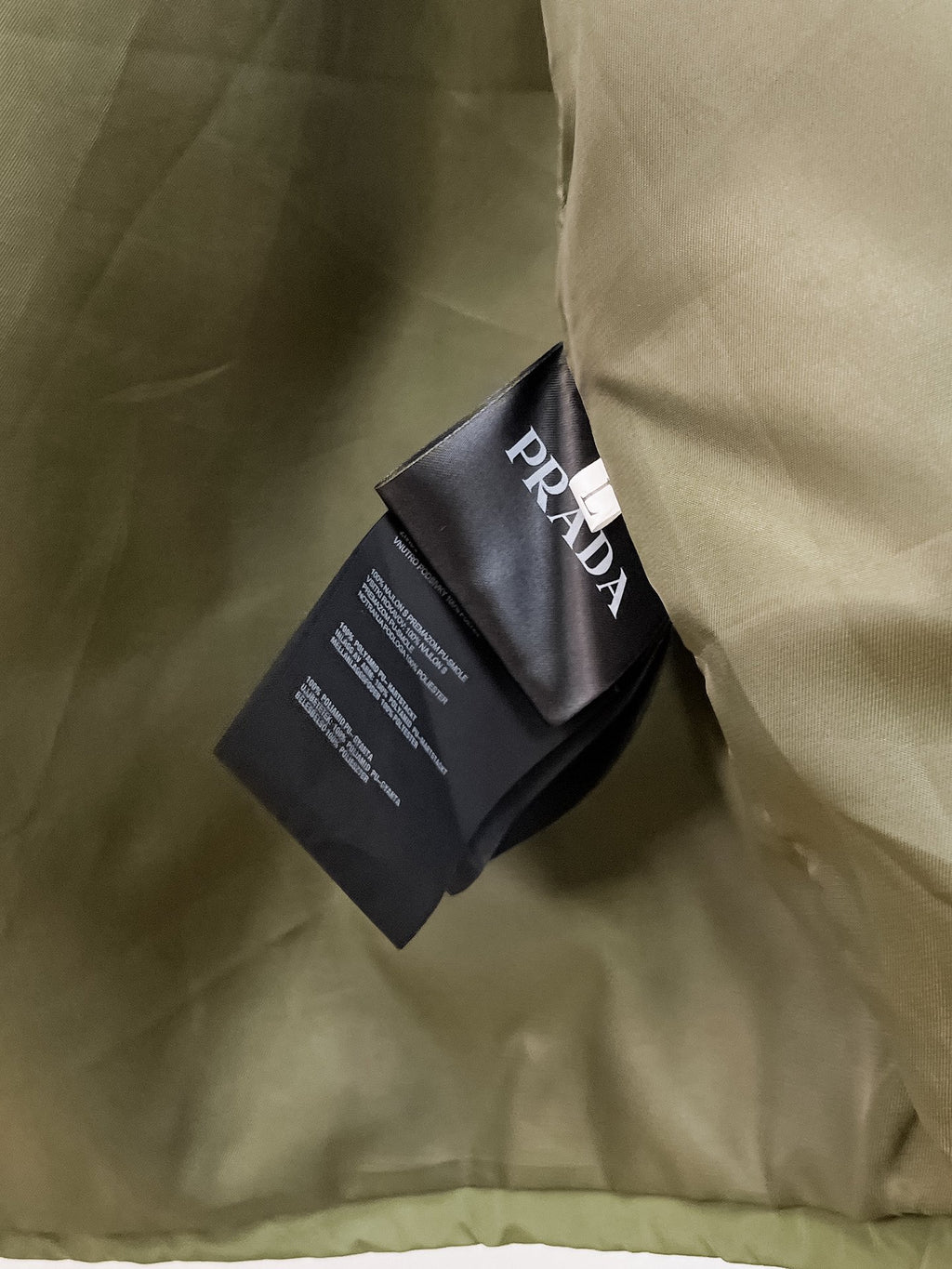 Long olive garment with black Prada tag