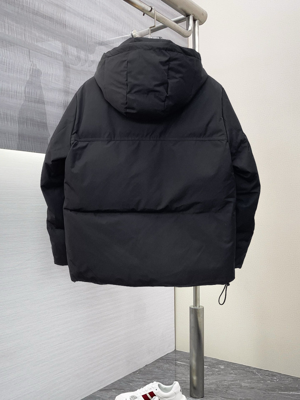 Black long puffer jacket back view with hood and stitched shoulder panels