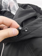 Black puffer jacket drawcord with round toggle stopper near the hood