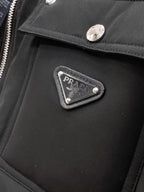 Black puffer jacket chest pocket close-up with triangular logo patch