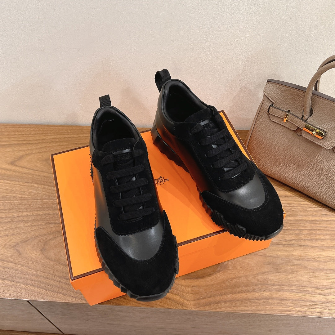 Unisex sneakers pair, black upper with gray side panel and black lace-up design