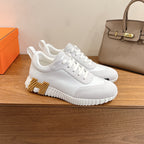 White low-top sneakers with lace-up closure and bold textured midsole