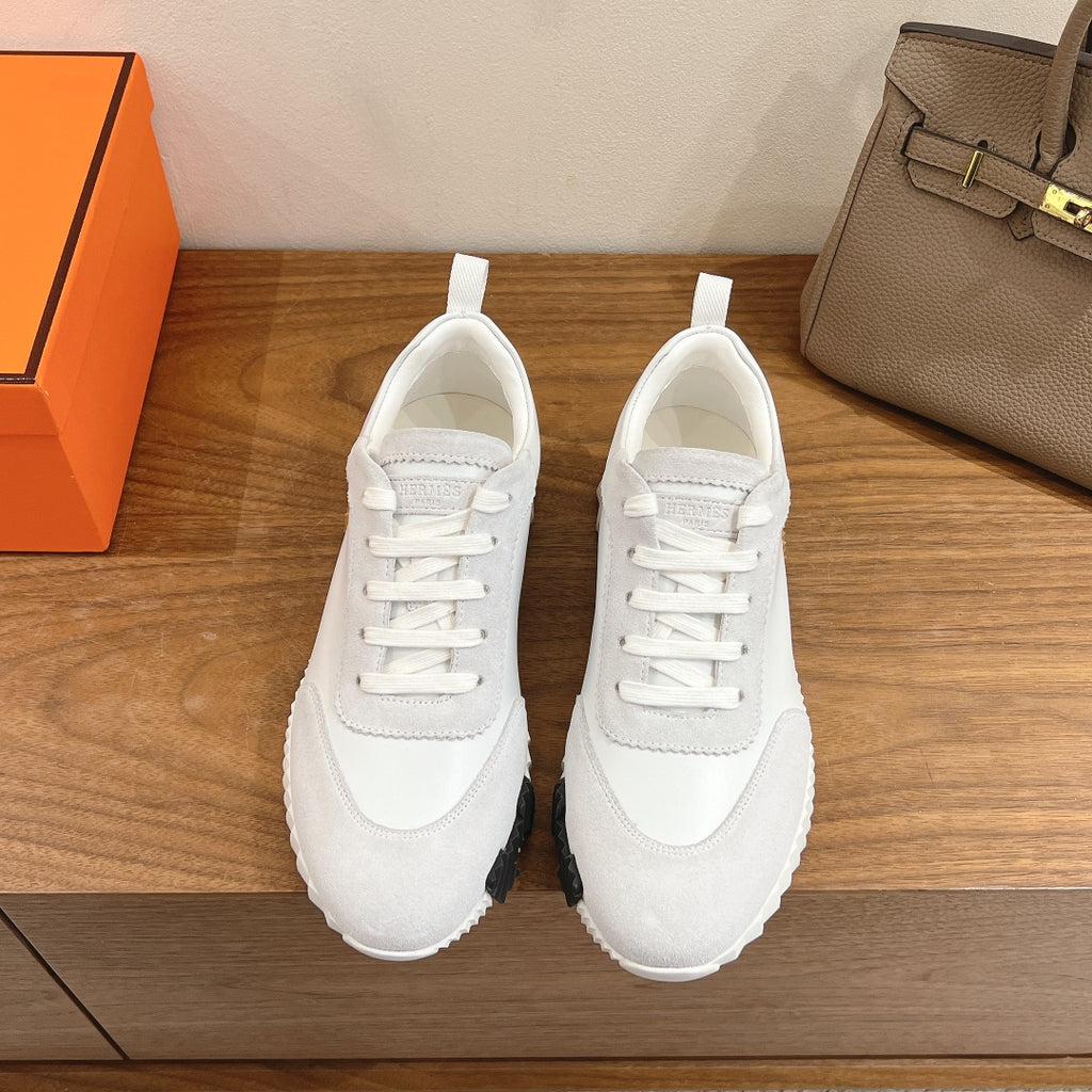 White lace-up low-top sneakers with thick rubber sole and padded collar