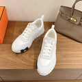 White lace-up sneakers, side profile, with chunky outsole and clean leather uppers