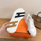 Shoe outsole view of white sneakers with textured tread and bold logo