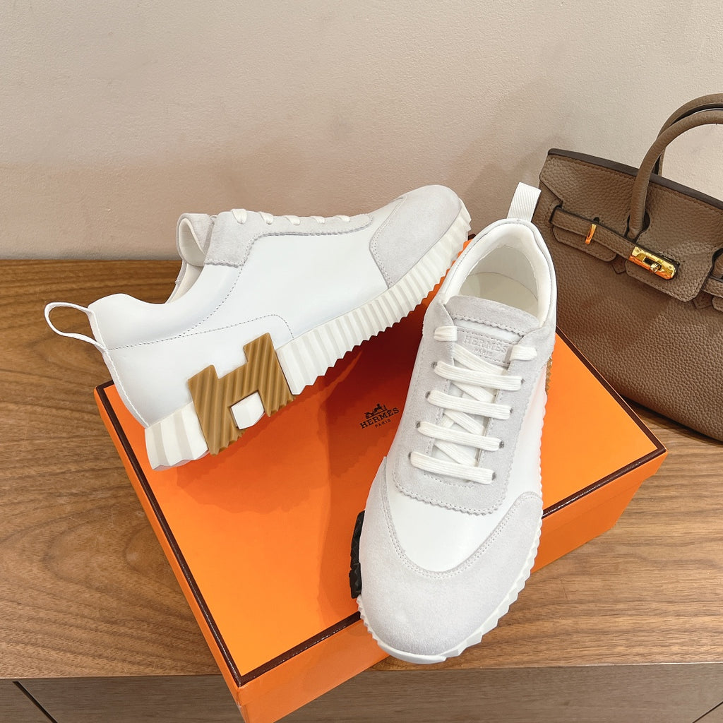 White lace-up sneakers with padded collar and chunky outsole, side and heel view