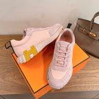 Hermes pink sneakers, one side showing yellow tread detail and lace-up upper