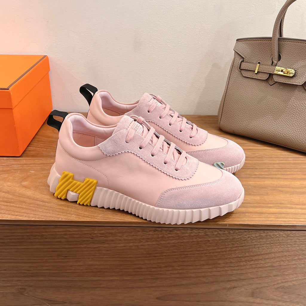 Hermes pink platform sneakers with lace-up front, thick sole, and yellow tread