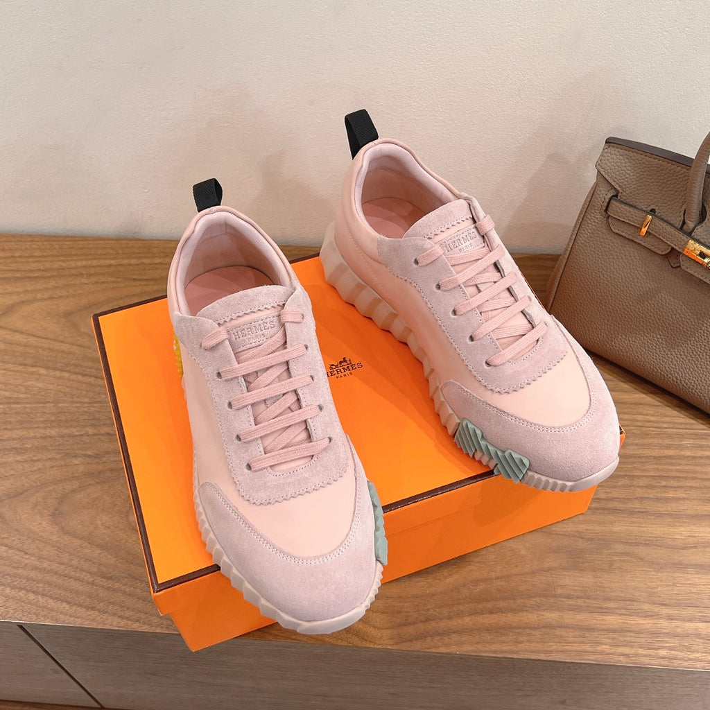 Hermes pink sneakers on box, angled view with lace-up closure and sporty sole