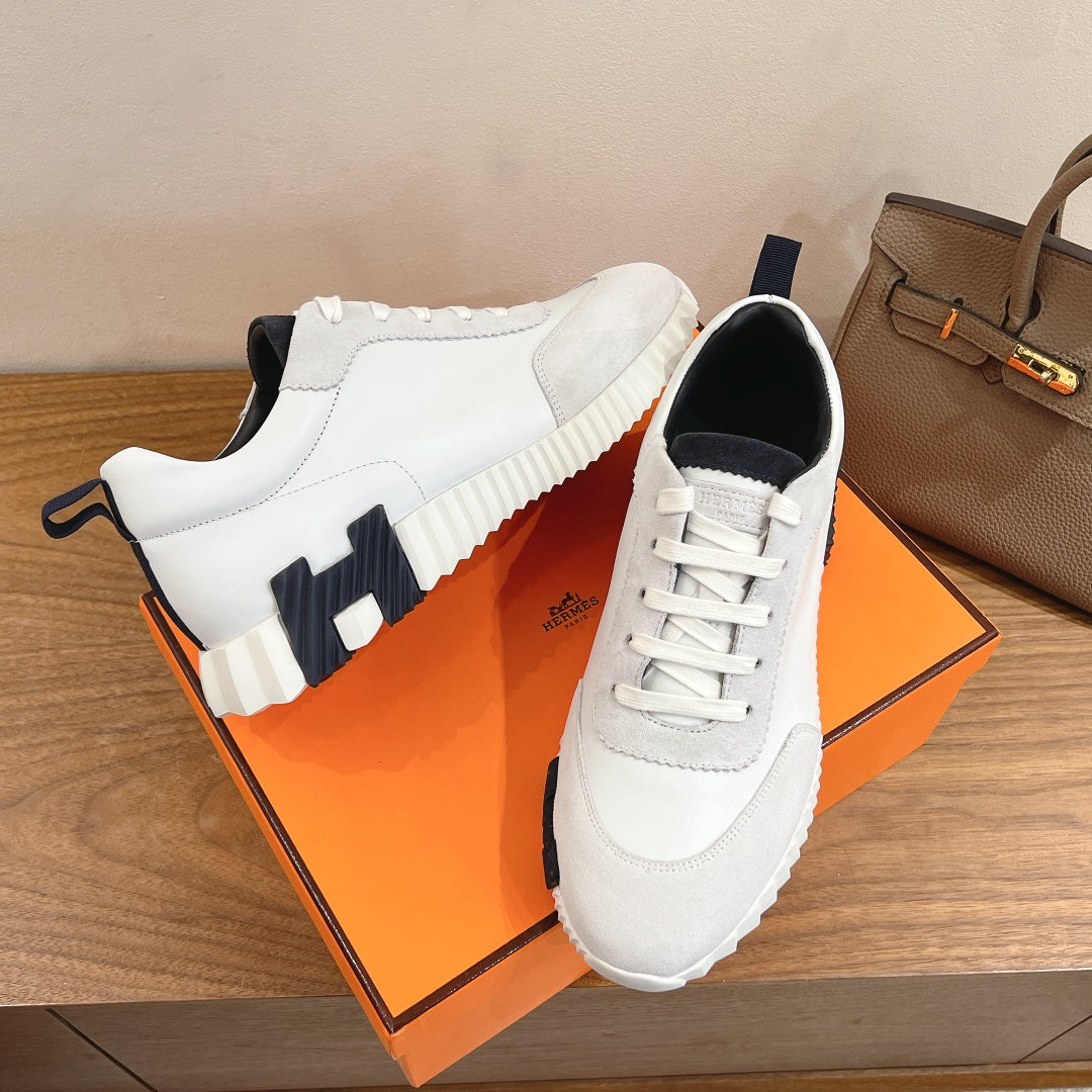White lace-up sneakers with navy panel accents and thick sole, Hermes unisex.