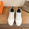 Hermes unisex sneakers, white leather with navy accents and lace-up design.