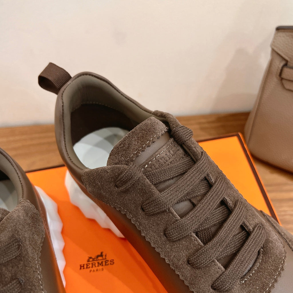 Hermes unisex sneaker close-up with taupe laces, suede tongue, and white sidewall