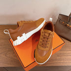 Tan lace-up sneakers with suede overlays and white ridged sole