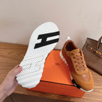 White tread outsole with black pattern on tan sneaker, laid on box
