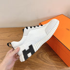 Unisex luxury sneakers, white slip-on style with black accents and ribbed sole