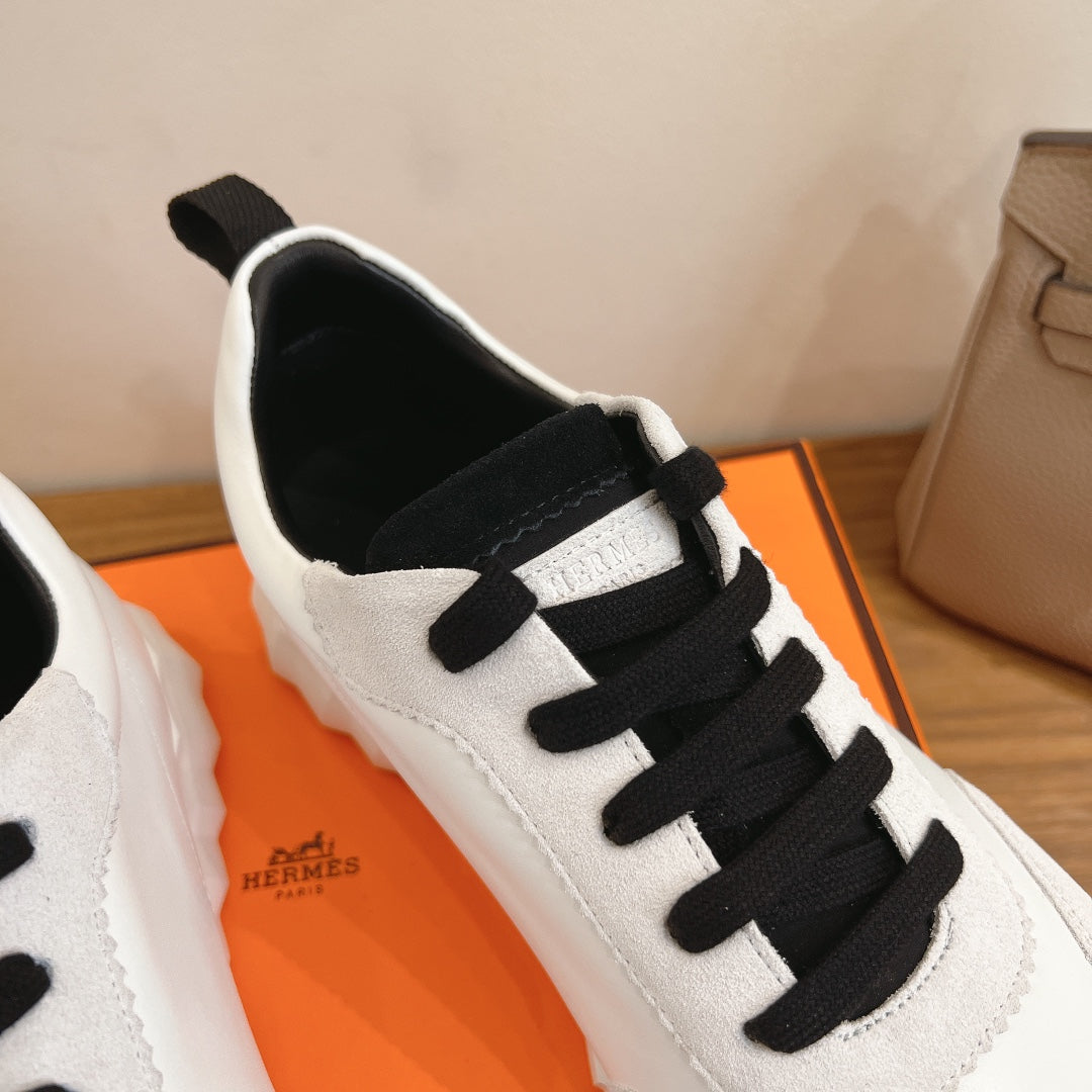 Unisex luxury sneakers, close-up white leather with black laces and side trim