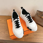 Unisex luxury sneakers, white uppers with black lace-up panels and thick sole