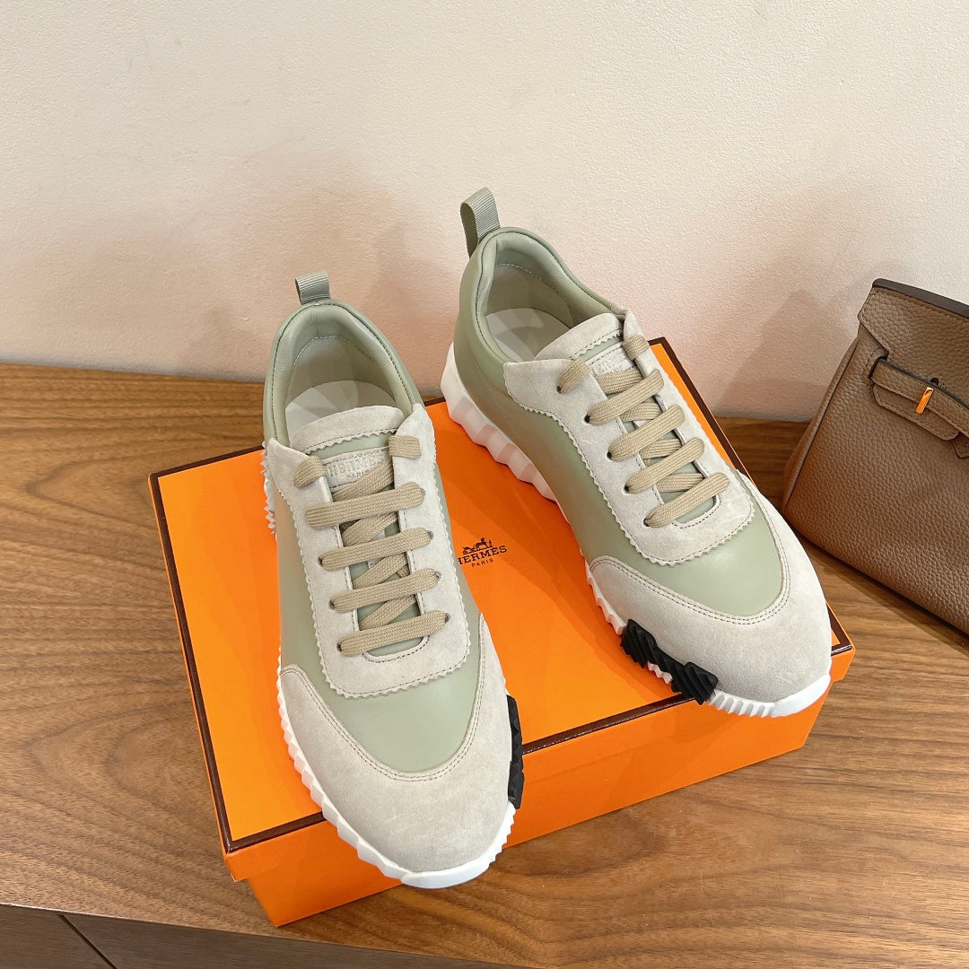 Pair of pale green and off-white lace-up sneakers with contrast stitching and white sole