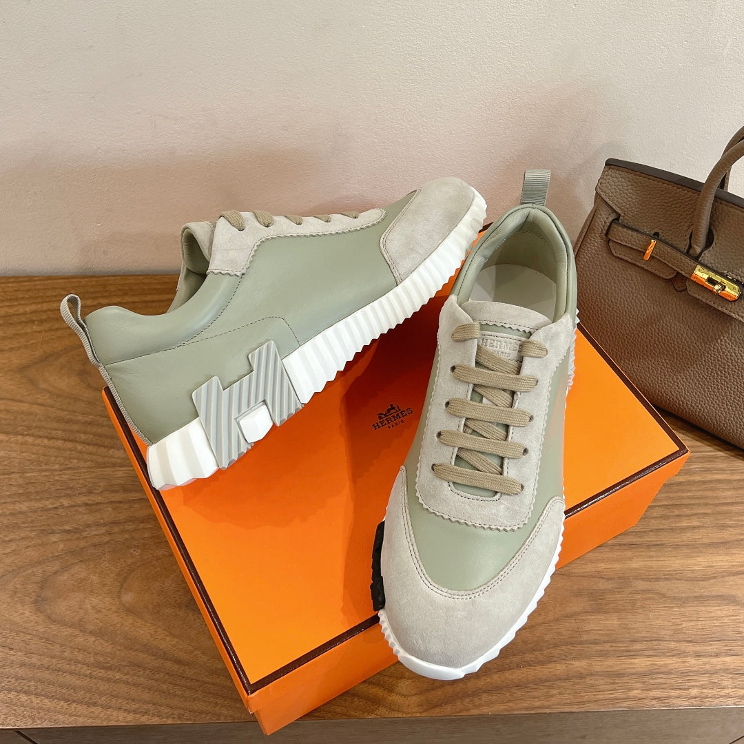 Unisex sneakers in pale green and off-white on box, featuring lace-up design and chunky sole