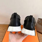 Back view of black sneakers with white platform sole and pull-on heel tabs