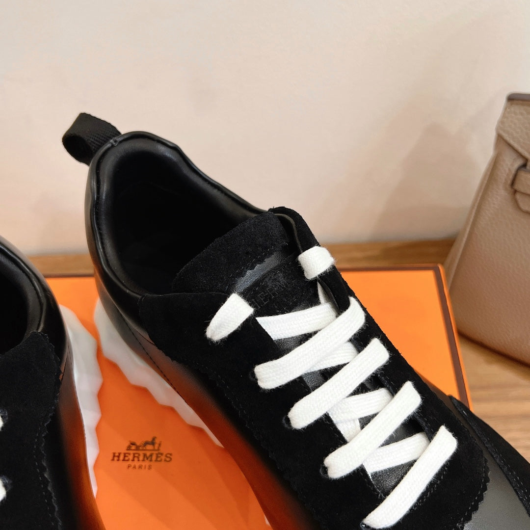 Close-up of black sneaker with white laces and side logo on the tongue