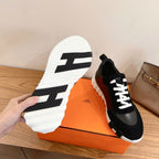 Outsole view of black sneakers showing thick white rubber tread pattern