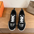 Black low-top sneakers with white laces and chunky white rubber sole
