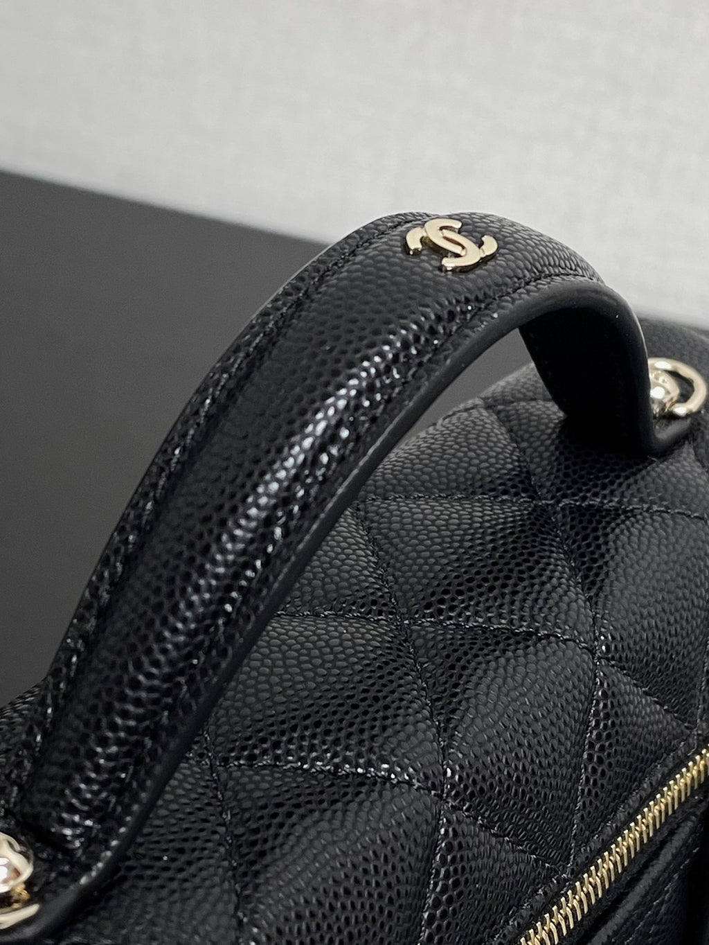 Chanel bag handle and quilted texture close-up with gold double C emblem