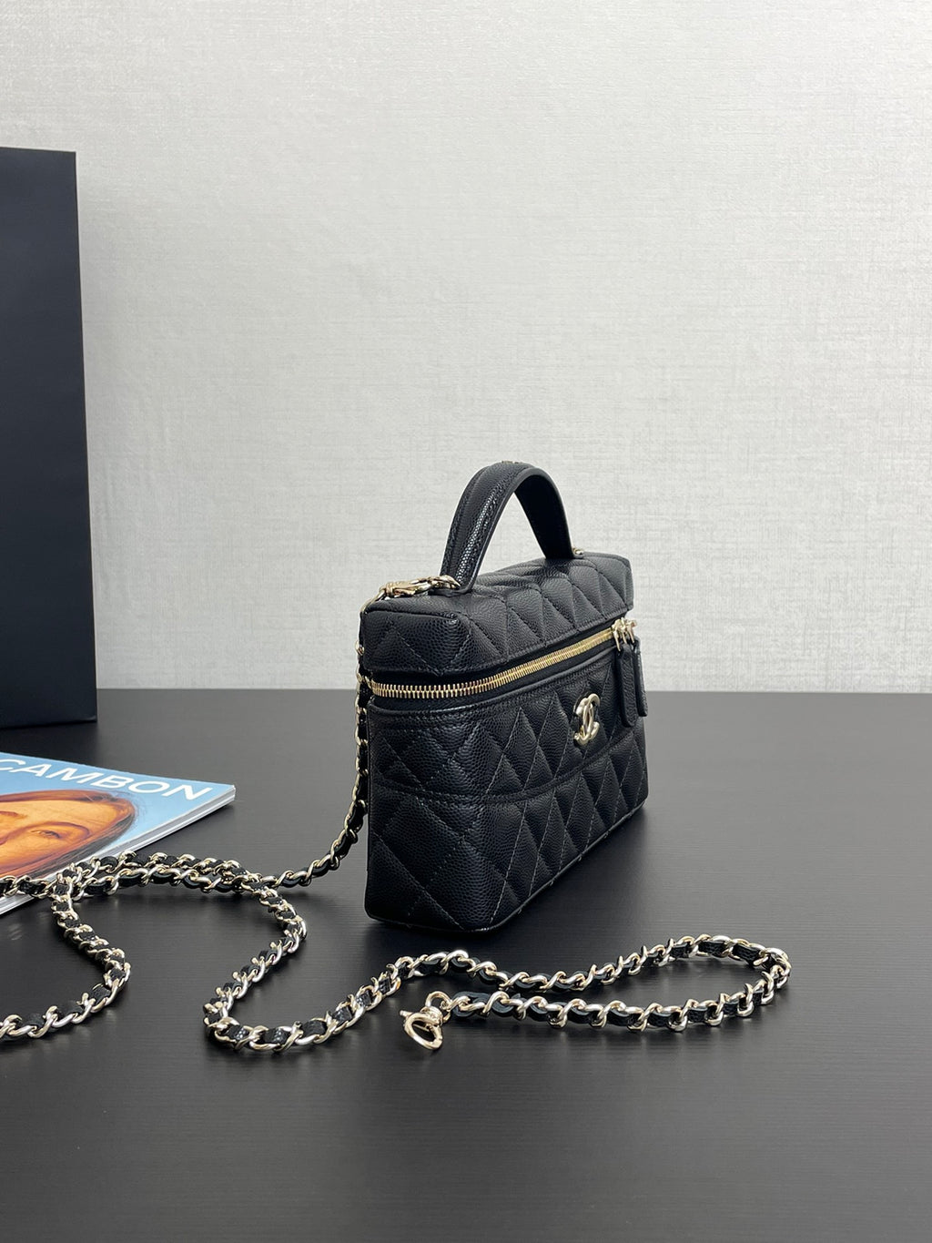 Chanel quilted top-handle bag with gold-tone hardware, chain strap, and front zipper