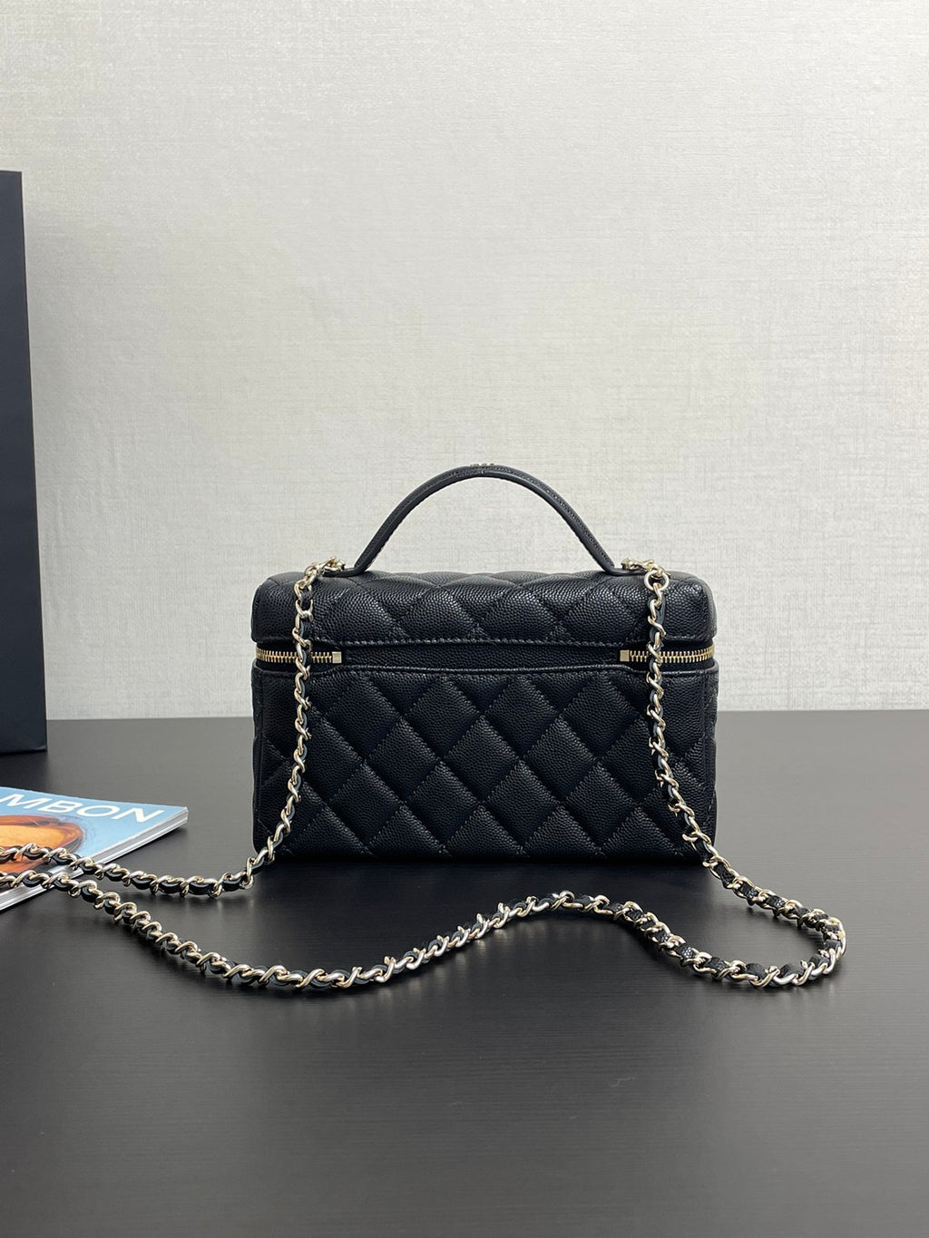 Chanel quilted mini bag with top handle, gold-tone logo, and front zipper detail